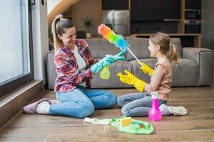 feliz mãe e filha tendo Diversão enquanto limpeza casa juntos foto