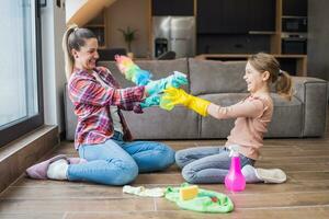 feliz mãe e filha tendo Diversão enquanto limpeza casa juntos foto