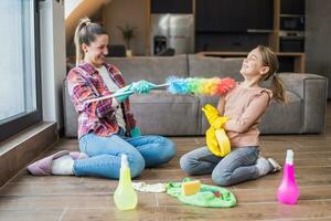 feliz mãe e filha tendo Diversão enquanto limpeza casa juntos foto