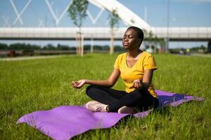 jovem mulher goza meditando ao ar livre foto