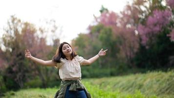 menina asiática sorri maliciosamente e se vira para a câmera durante um passeio pela natureza. foto