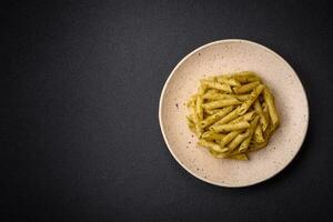 delicioso fresco massa Macarrão Penne com verde pesto molho com manjericão, sal e especiarias foto