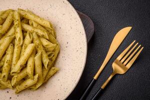 delicioso fresco massa Macarrão Penne com verde pesto molho com manjericão, sal e especiarias foto