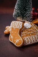 lindo delicioso doce inverno Natal Pão de gengibre biscoitos em uma bronze texturizado fundo foto