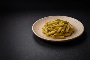 delicioso fresco massa Macarrão Penne com verde pesto molho com manjericão, sal e especiarias foto