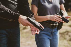 uma menina aprende para tiro uma pistola às uma tiroteio alcance com a instrutor foto