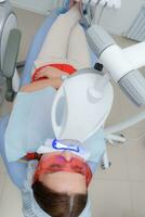 a paciente sofre uma procedimento para dentes branqueamento com a ultravioleta luminária foto