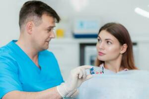ortodontista vai explicar para a paciente quão a prato alinha a dentes foto