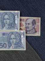 notas bancárias croatas empilhadas entre tecido jeans azul foto