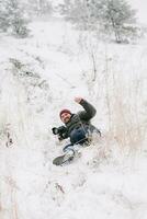 alegre viajante fotógrafo escorregou e caiu em neve foto