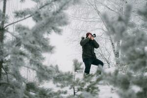 viajante fotógrafo levando As fotos dentro a inverno floresta