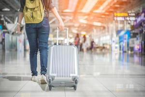 bela mulher asiática viajando e segurando uma mala no aeroporto foto