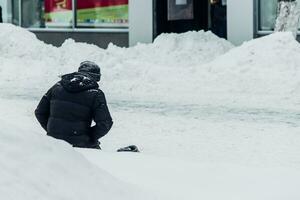 sem teto homem implora para esmolas joelhos dentro a neve foto