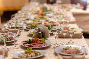 servido festivo mesa com lanches, copos, copos, talheres e guardanapos para uma banquete foto