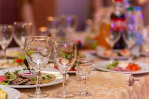 servido festivo mesa com lanches, copos, copos, talheres e guardanapos para uma banquete foto