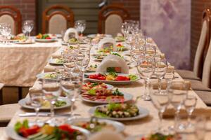 servido festivo mesa com lanches, copos, copos, talheres e guardanapos para uma banquete foto