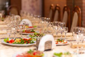 servido festivo mesa com lanches, copos, copos, talheres e guardanapos para uma banquete foto