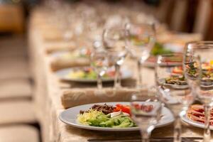 servido festivo mesa com lanches, copos, copos, talheres e guardanapos para uma banquete foto