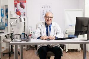 especialista médico vestindo branco casaco dentro hospital gabinete. médico sorridente. foto