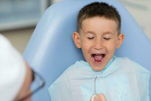 a dentista tocam com uma pequeno paciente tão este ele é não receoso para tratar dele dentes foto