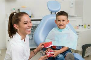 a ortodontista entretém a pequeno paciente tão este ele é não receoso para tratar dele dentes foto