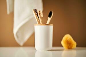 bambu escovas de dente dentro uma copo e uma toalha dentro uma banheiro interior. foto