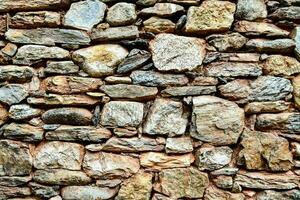 uma parede fez do pedra com muitos diferente tipos do pedras foto