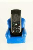 uma célula telefone sentado em uma azul cadeira foto