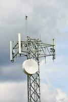 uma célula telefone torre com uma satélite prato em topo foto