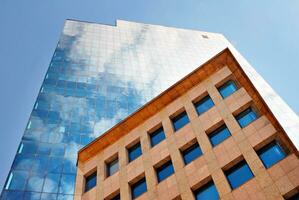 estrutural vidro parede refletindo azul céu. abstrato moderno arquitetura fragmento. foto