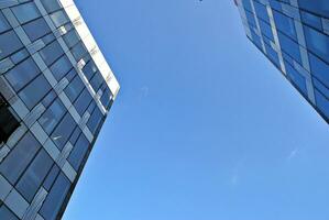 estrutural vidro parede refletindo azul céu. abstrato moderno arquitetura fragmento. foto