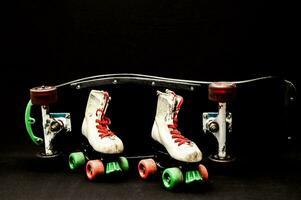 uma skate com dois pares do rolo patins foto