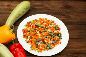 congeladas legumes cenouras, ervilhas, feijões dentro uma prato foto