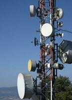 telecomunicação antena com múltiplo satélite contra a azul céu foto