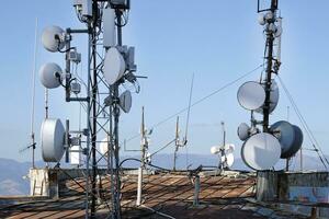 telecomunicação antena com múltiplo satélite contra a azul céu foto