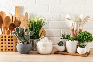 conjunto diferente cozinha utensílios e conjunto do diferente verde em vaso plantas em uma de madeira cozinha bancada dentro a ecológico cozinha. frente visualizar. foto