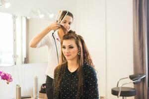 cabeleireiro fazendo corte de cabelo para mulheres dentro cabeleireiro salão. conceito do moda e beleza. positivo emoção. foto