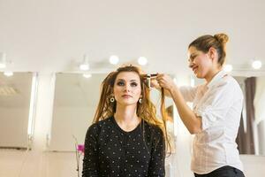 cabeleireiro fazendo cabelo estilo para mulher. conceito do moda e beleza foto