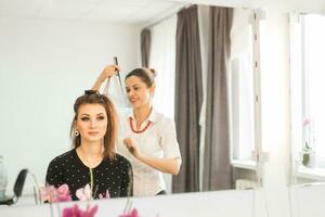 cabeleireiro fazendo corte de cabelo para mulheres dentro cabeleireiro salão. conceito do moda e beleza. positivo emoção. foto