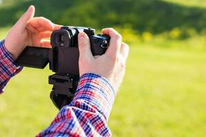 profissional fotógrafo ajusta a Câmera antes tiroteio, mãos foto
