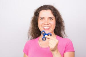 jovem mulher jogando com uma inquietação spinner foto