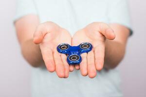 jovem homem segurando com uma inquietação spinner fechar acima foto