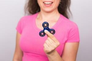 jovem mulher jogando com uma inquietação girador, foco em spinner. foto