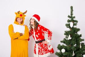 feliz jovem mulher dentro santa claus chapéu e homem dentro carnaval traje do cervo. diversão, feriado, Piada e Natal conceito foto