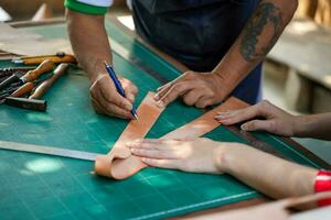 fechar-se e colheita equipe do couros criador é desenhando uma Projeto em couro dentro couro oficina. foto