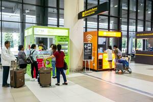 Bangkok, º, 2018 - turistas estão Perguntando preço e quão para usar aluguel Wi-fi e Móvel telefone sim cartão para turista às estandes ficar de pé dentro não mueang internacional aeroporto. foto