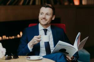 homem de negocios desfrutando café enquanto lendo uma revista dentro uma acolhedor interior. foto
