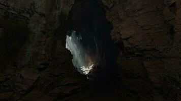 uma hipnotizante caverna com uma raio do luz solar transmissão através uma pequeno abertura foto