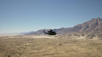 uma helicóptero vôo sobre uma deserto panorama com montanhas dentro a fundo foto