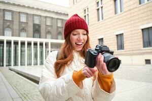 lindo cabeça de leitura garota, fotógrafo com profissional Câmera leva As fotos ao ar livre, caminhando por aí cidade e levando fotos, passeios turísticos